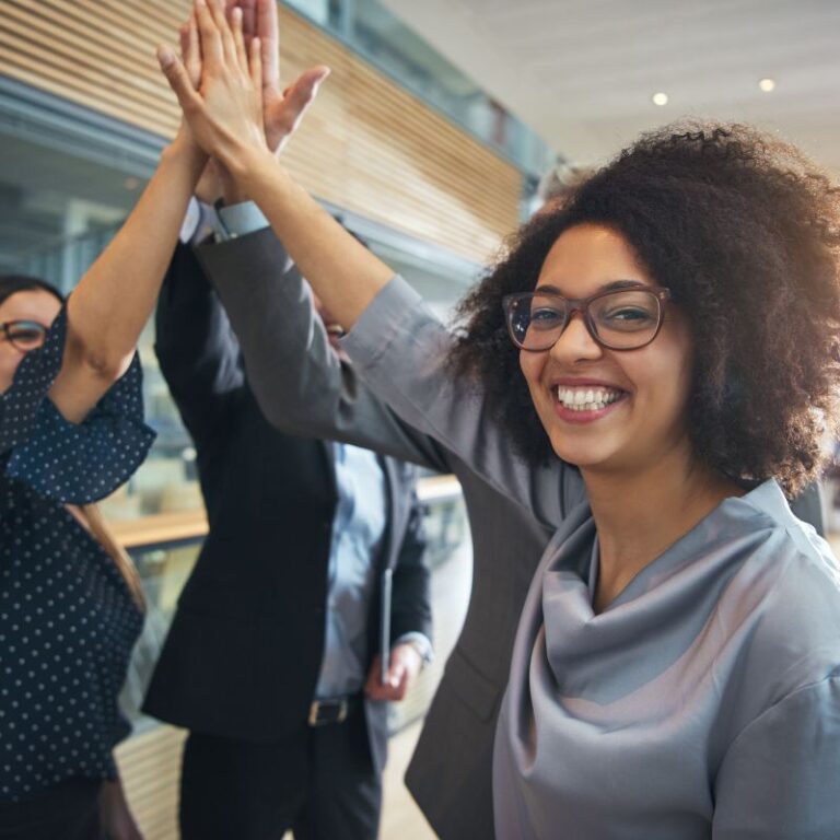 Smiling team members giving high fives