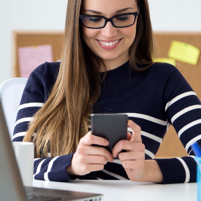 Woman looking at a smartphone, smiling.