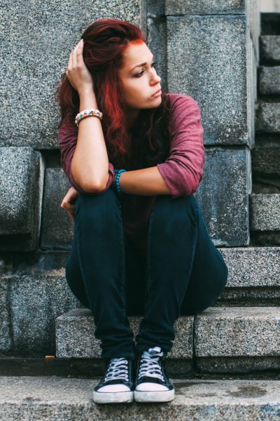 Thoughtful woman sitting on stone steps