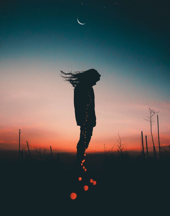 Silhouette of person at sunset with crescent moon.