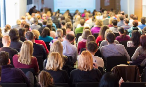 Audience attending a conference in a lecture hall.