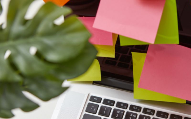 Colorful sticky notes on laptop keyboard.