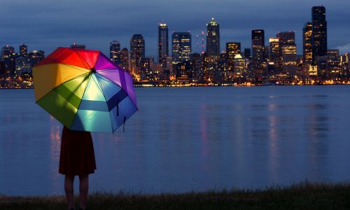 Colorful umbrella against city skyline at night.