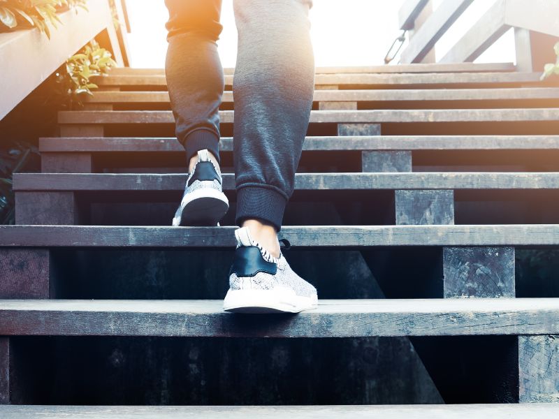Person climbing outdoor steps in athletic sneakers.
